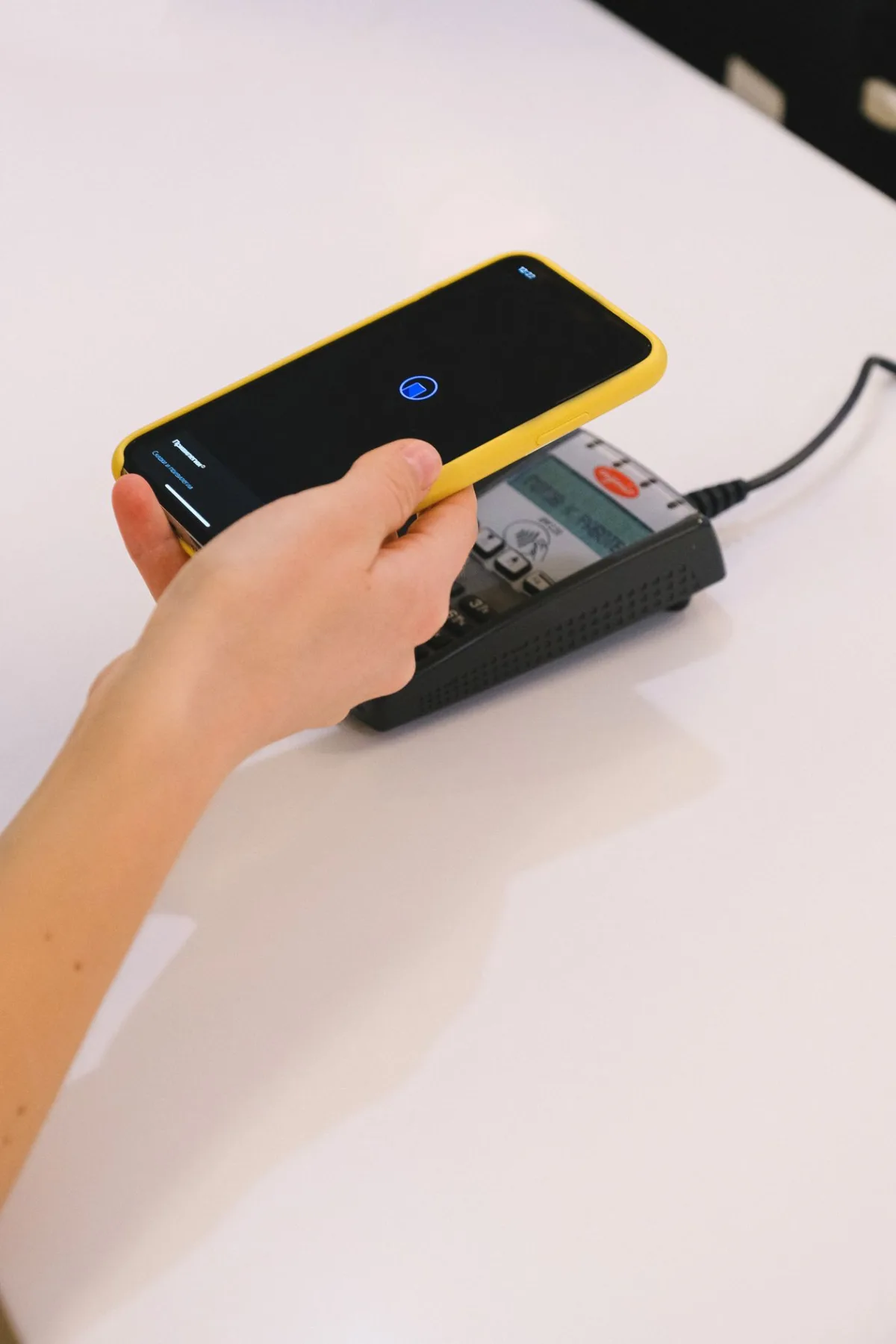A customer making a contactless mobile payment at a terminal