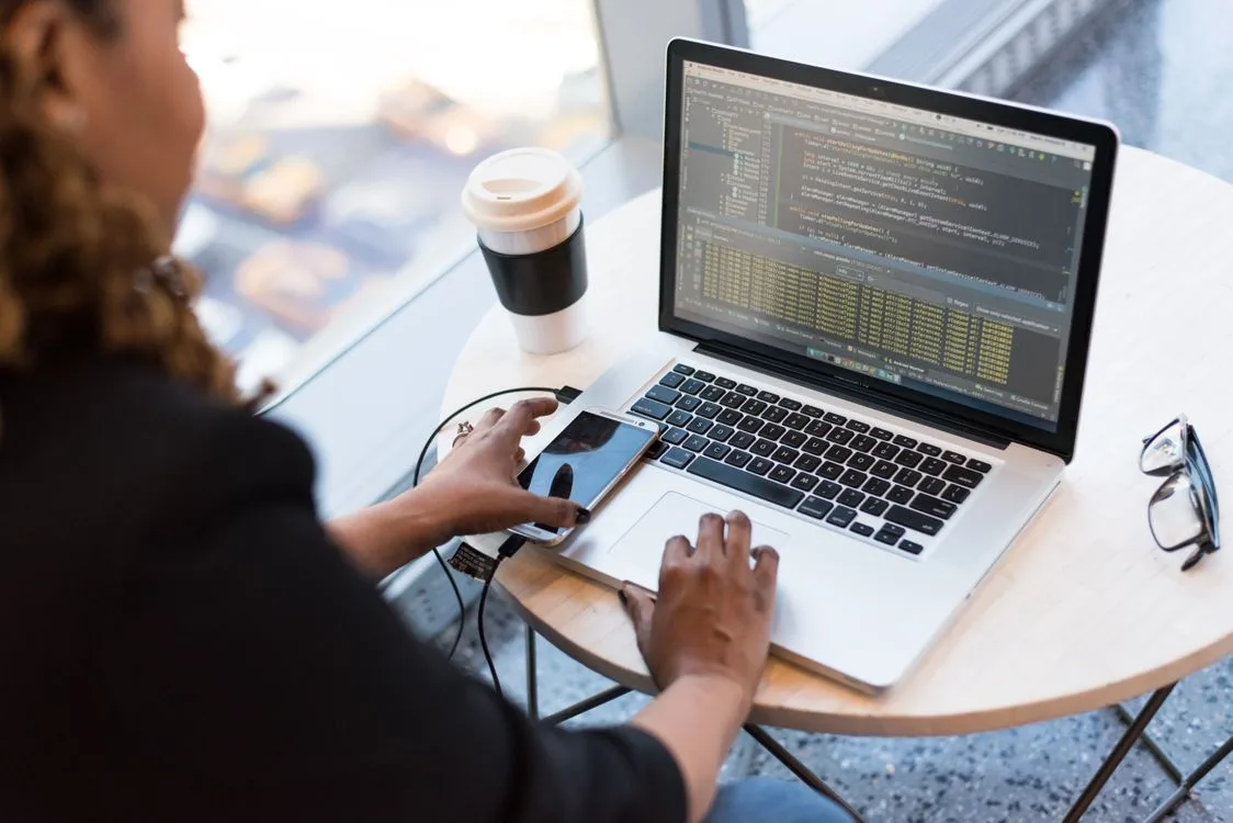 A Black developer programming on a laptop at a desk