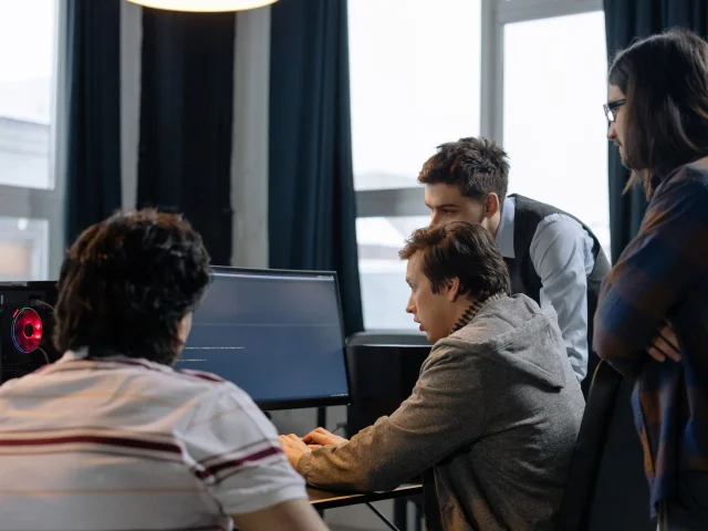 Developers collaborating at computers to solve a software problem